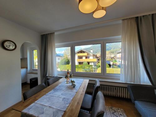 a living room with a large wooden table and large windows at BERG-LOVE in Garmisch-Partenkirchen