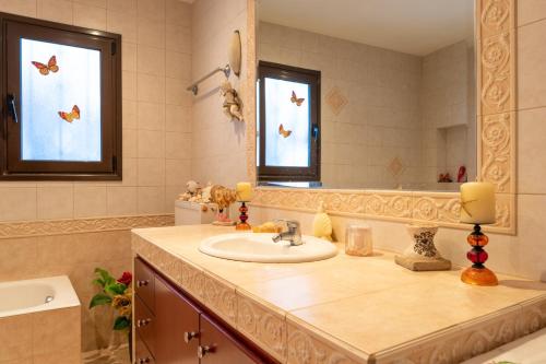 a bathroom with a sink and a mirror at AGGELIKI'S traditional country cottage in Topólia