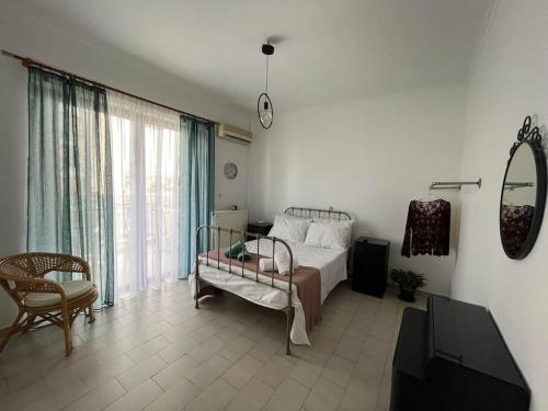 - une chambre avec un lit et une grande fenêtre dans l'établissement Mονοκατοικία - Mεζονέτα, à Athènes