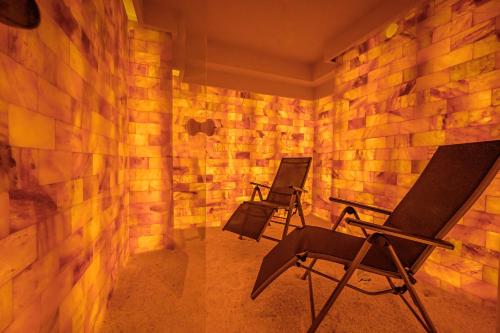 two chairs in a room with a brick wall at Hotel Schwarzbachtal Hideaway in Erlbach