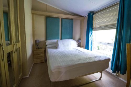 een kleine slaapkamer met een bed en een raam bij Beautiful 6 Berth Lodge At Cherry Tree Holiday Park Ref 70002tg in Great Yarmouth
