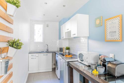 uma cozinha com armários brancos e uma bancada em Bright apartment - 2BR - Place de la BastilleSt Antoine em Paris