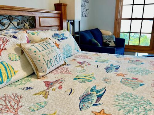 a bed with a comforter with fish on it at The Torch Lake Bed and Breakfast in Central Lake