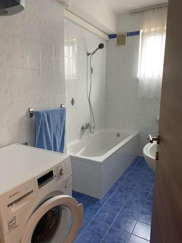 a white bathroom with a washing machine in it at Apartment Chie in Izola