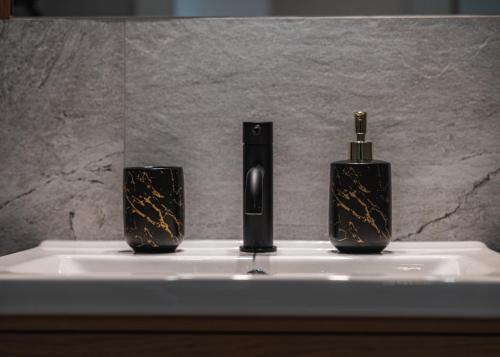 un lavabo de salle de bain avec deux bouteilles de savon dessus dans l'établissement Apartament w sercu Wrocławia, garaż, 5min do Rynku, à Wrocław