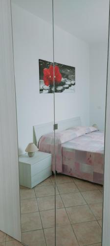 a bedroom with a bed and a glass door at Lovely House risveglio fronte mare in Marina di Pescoluse