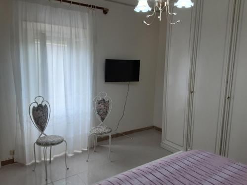 a bedroom with two chairs and a tv and a bed at La casetta nella Tuscia in Viterbo