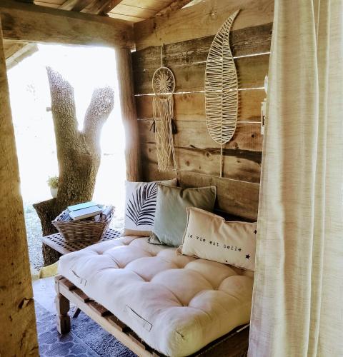 - un canapé blanc dans une chambre avec fenêtre dans l'établissement Au Fil de Soi, à Vézénobres