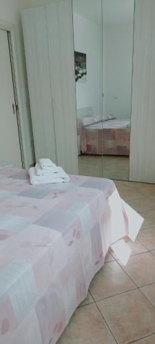 a pink bed in a room with a glass wall at Lovely House risveglio fronte mare in Marina di Pescoluse