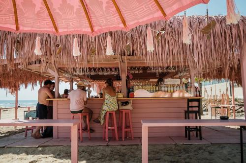 a group of people sitting at a bar on the beach at ON Hotels Oceanfront Adults Designed in Matalascañas