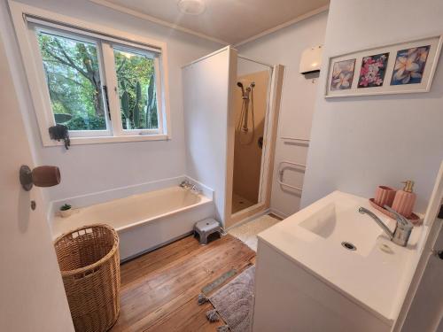 a bathroom with a tub and a sink at La Petite Ferme Manor Kerikeri in Kerikeri
