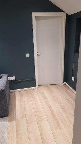 ein leeres Zimmer mit einer Tür und einem Holzboden in der Unterkunft 1Mart Lane Burscough in Burscough