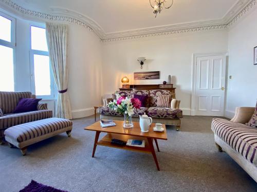 uma sala de estar com dois sofás e uma mesa de centro em Dairsie Sea View em Rothesay