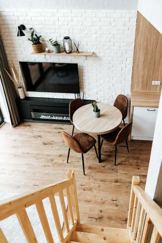 a room with a table and chairs and a fireplace at Okno Na Ślężę in Sady