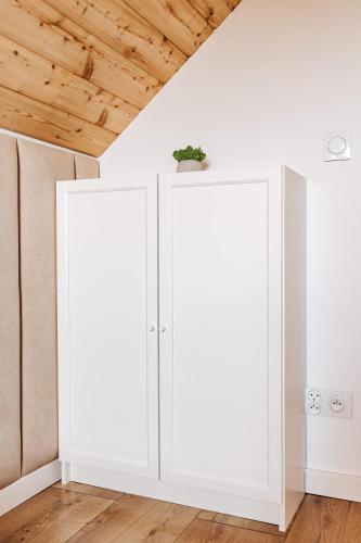 a pair of white cabinets in a room with a ceiling at Okno Na Ślężę in Sady