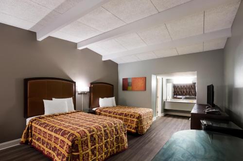 費耶特維爾的住宿－費耶特維爾布拉格堡騎士旅館，酒店客房设有两张床和电视。