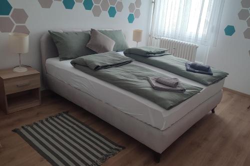 - une chambre avec un lit doté de draps et d'oreillers verts dans l'établissement La Vista, à Loznica