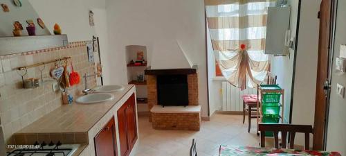a kitchen with two sinks and a fireplace in it at CASA PIERA in Acciano