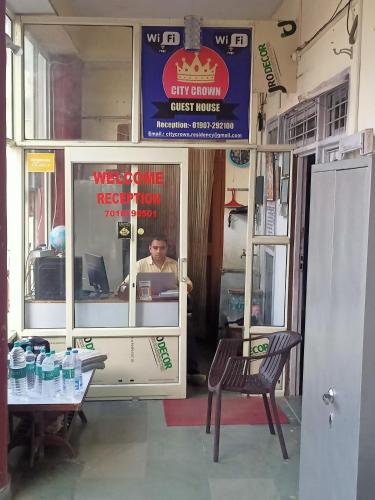 a man sitting at a counter in a restaurant at CITY CROWN GUEST HOUSE in Sundarnagar