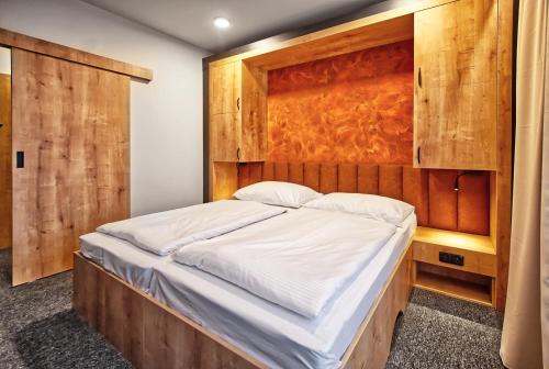 a bedroom with a large bed with a wooden headboard at Restaurace a Penzion Praha in Dolní Dunajovice