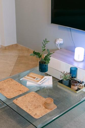 a glass table with a bed and plants on it at The Art Suite in Patra