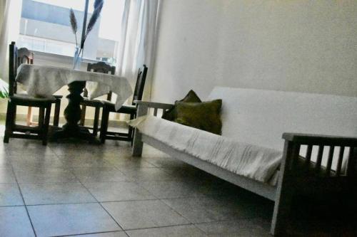 um gato sentado numa cama num quarto em Departamento en ciudad cultural em San Salvador de Jujuy