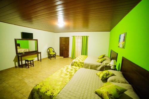 El Molino的住宿－La Arboleda Colonial Hotel，一间卧室配有两张床和一张带镜子的书桌