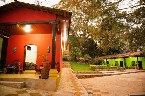 a red and green house with a patio at La Arboleda Colonial Hotel in El Molino