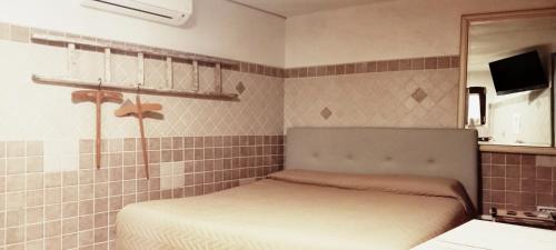 a small bedroom with a bed and a mirror at La Torretta in Santeramo in Colle