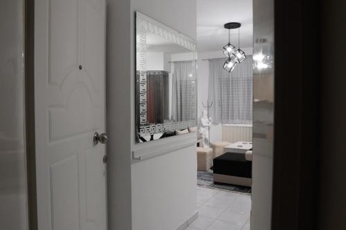 baño con espejo y puerta blanca en Poseidon's Premium Apartment, en Katerini