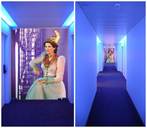
a woman is standing in a room with a mirror at arte Hotel Linz in Linz
