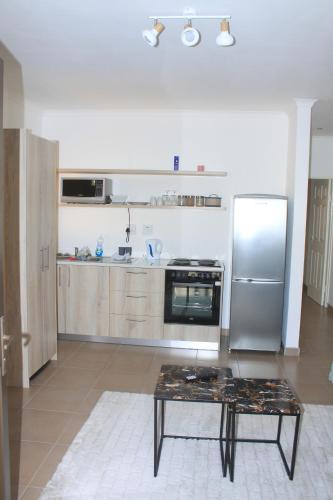 eine Küche mit einem Edelstahlkühlschrank und einem Tisch in der Unterkunft Casa Decha in Windhoek