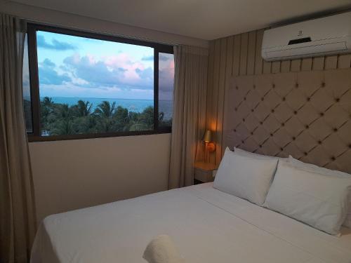 a bedroom with a bed and a large window at Amaranth Beach Class - MH in Cabedelo