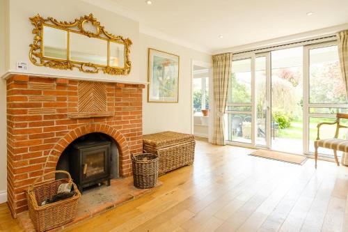 a living room with a brick fireplace with a mirror at Turret House, Thorpeness - Close to the beach, Thorpeness Lake , Thorpeness Hotel, Golf and Country Club - Aldeburgh Coastal Cottages in Thorpeness