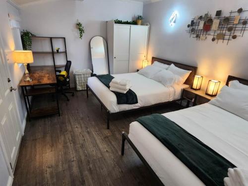 een slaapkamer met 2 bedden, een bureau en een spiegel bij Guest House with Amazing views and Sauna in Monterey Park
