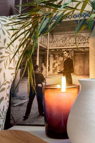Una vela en un jarrón junto a una mujer en Precioso apartamento en centro de Madrid, en Madrid
