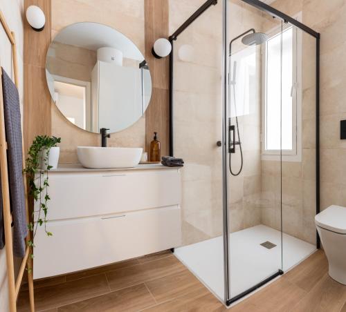y baño con ducha, lavabo y espejo. en Precioso apartamento en centro de Madrid, en Madrid