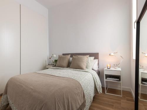 Habitación blanca con cama y mesita de noche en Precioso apartamento en centro de Madrid, en Madrid
