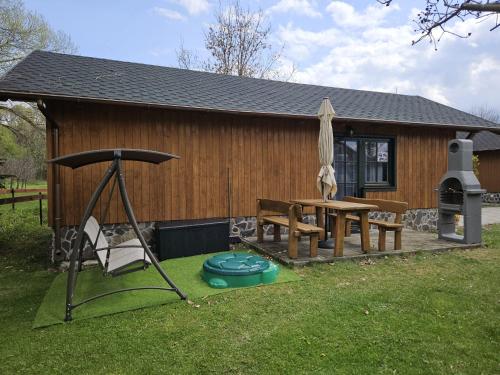 a house with a picnic table and an umbrella at chatka Tatralandia 433 Sofinka in Liptovský Mikuláš