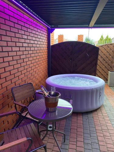 a hot tub on a patio with a table and chairs at Apartament "Love Island" z Jacuzzi SPA dla Dwojga in Gniezno