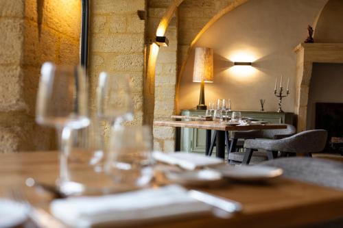 a restaurant with tables and chairs with wine glasses at Château de Collias in Collias