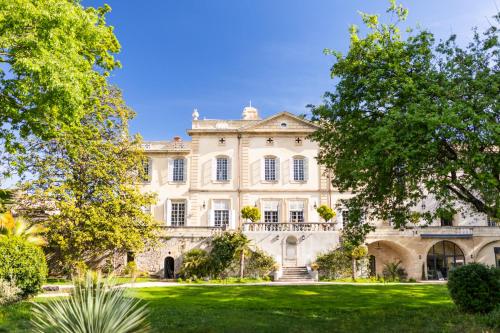 un vieux manoir avec des arbres devant lui dans l'établissement Château de Collias, à Collias