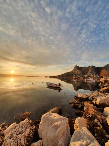 a boat is sitting in the water at sunset at Old Town Apartment in Omiš