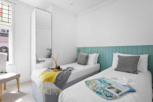 two beds in a room with green and white at Flat 2 Fairfax Place - Modern stylish flat with plenty of charm in central Dartmouth in Dartmouth