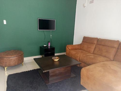 uma sala de estar com um sofá e uma mesa de centro em The Furnished Apartments em Livingstone