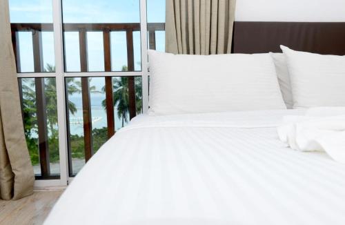 a white bed with a view of the ocean at Express Inn at Hulhumale in Hulhumale