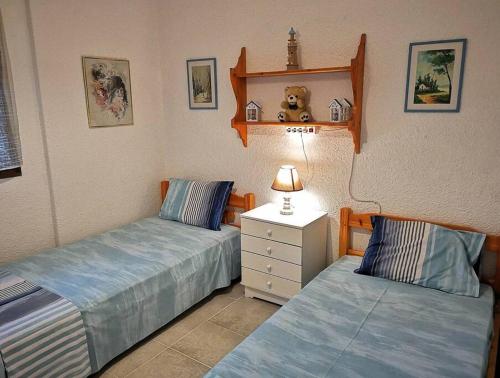 a bedroom with two beds and a teddy bear on a shelf at Golden Summer Apartment in Nea Fokea