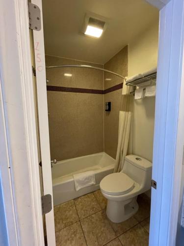 a bathroom with a toilet and a bath tub at La Casa Inn in Pasadena