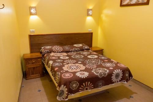 - une chambre avec un lit et deux lumières sur le mur dans l'établissement Hotel del Parque Naolinco, à Naolinco