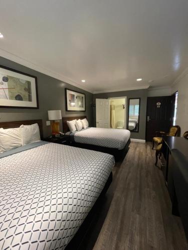 a hotel room with two beds and a desk at La Casa Inn in Pasadena
